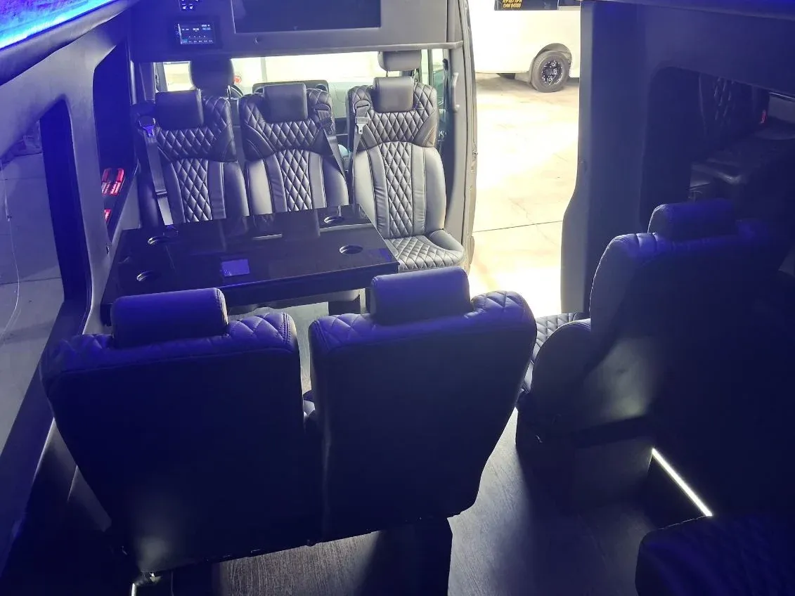 Black Luxury Sprinter Shuttle Van interior with captain's chairs, passenger tables and LED accent lighting, photo 3 for winery tour transport in Woodland Hills, CA
