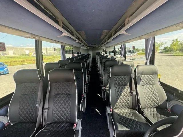 40 Passenger Charter Bus interior with window shades and overhead parcel racks for charter bus rental in Orlando, FL
