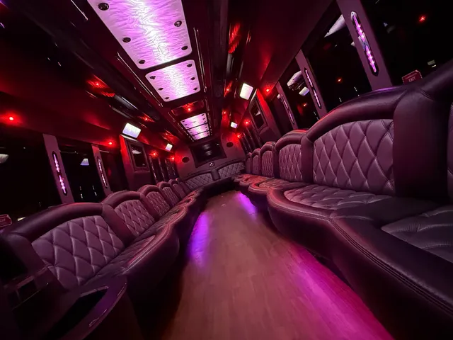 Freightliner Party BUS interior with perimeter lounge seating, LED ceiling lighting and wood-look flooring for party bus rental
