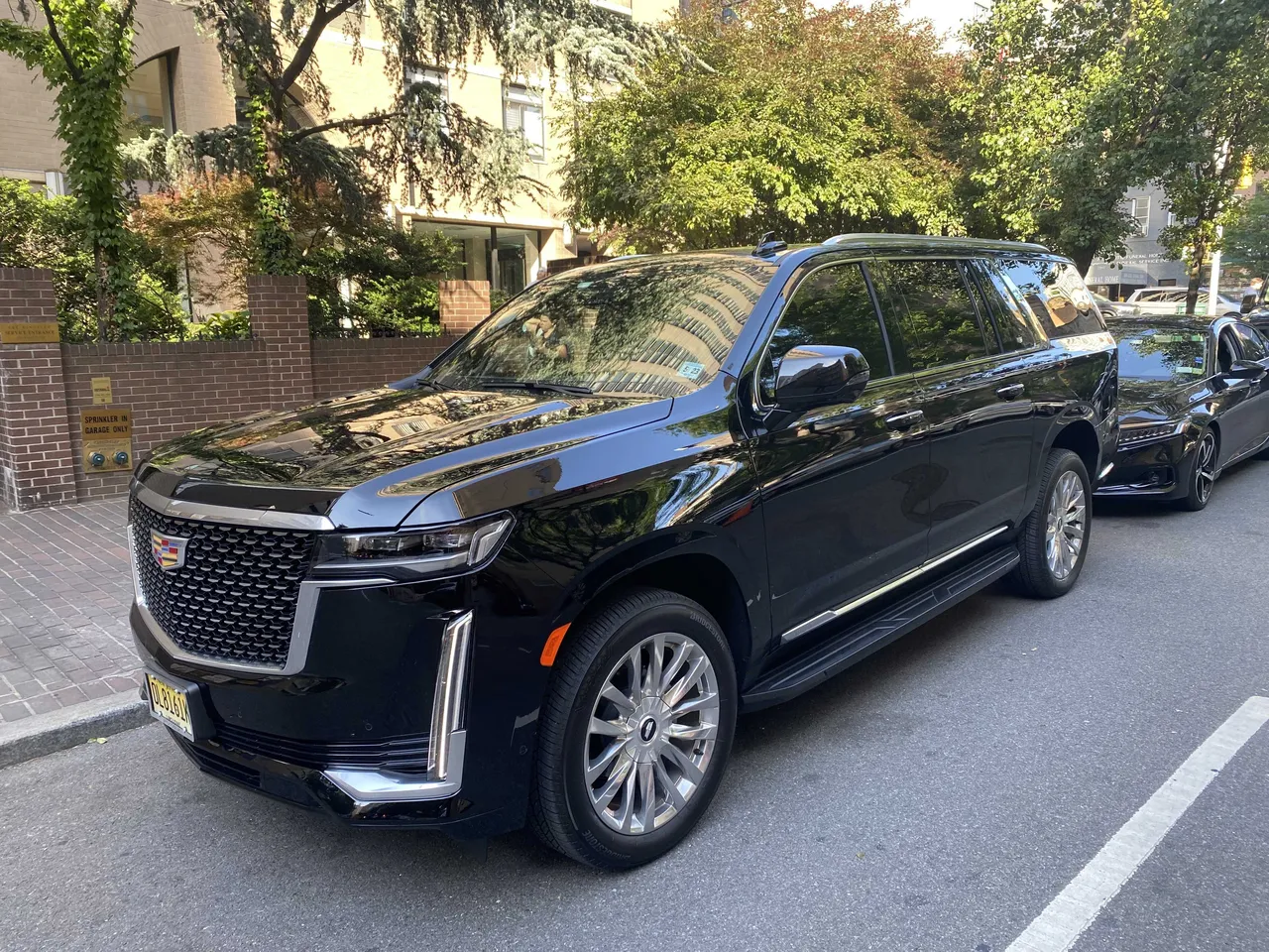 Black Cadillac Escalade exterior with tinted windows and running boards for airport transfers Black Cadillac Escalade exterior with tinted windows and running boards for airport transfers