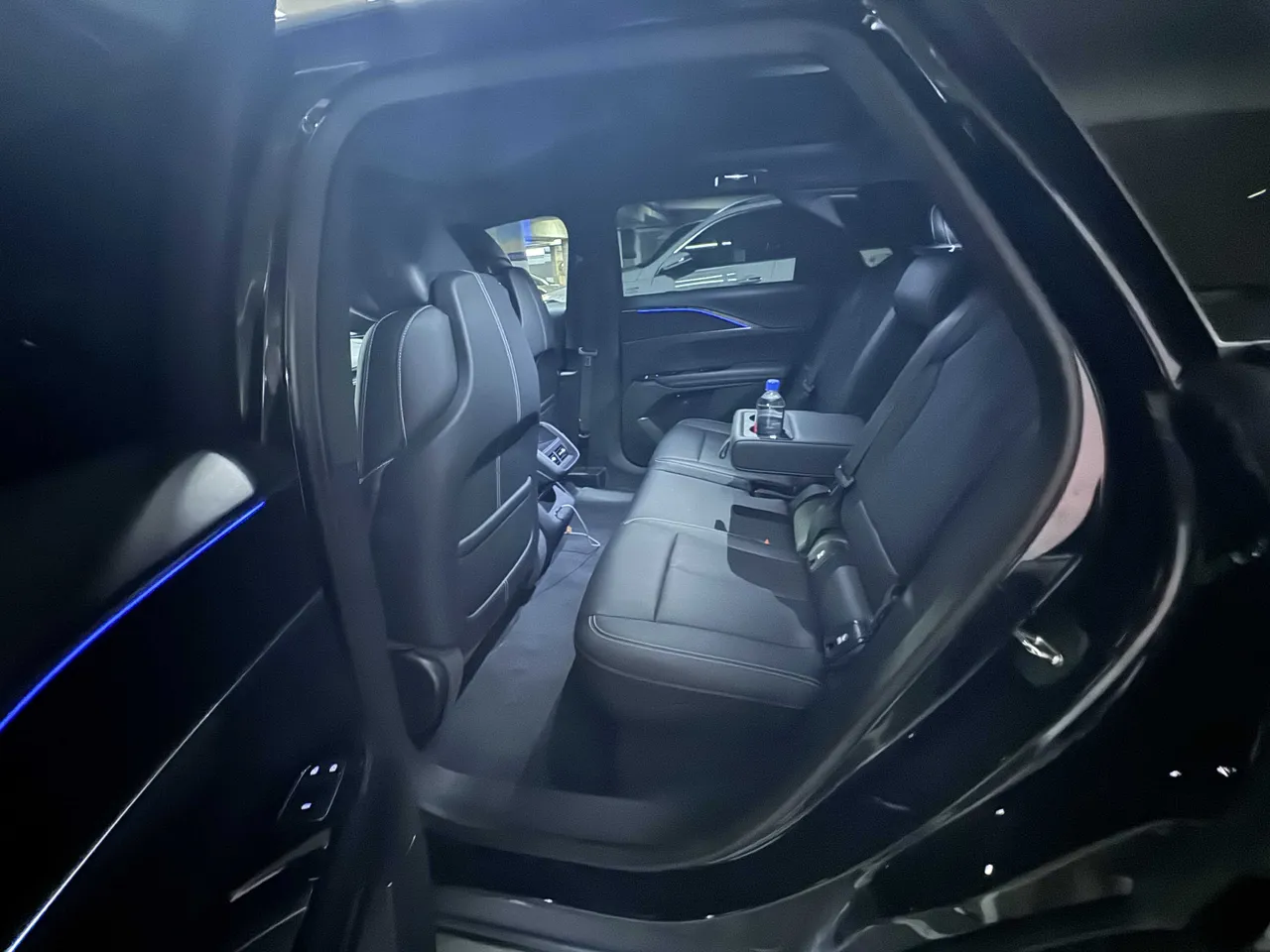 Cadillac Lyriq interior with cup holders and LED accent lighting for airport transfers