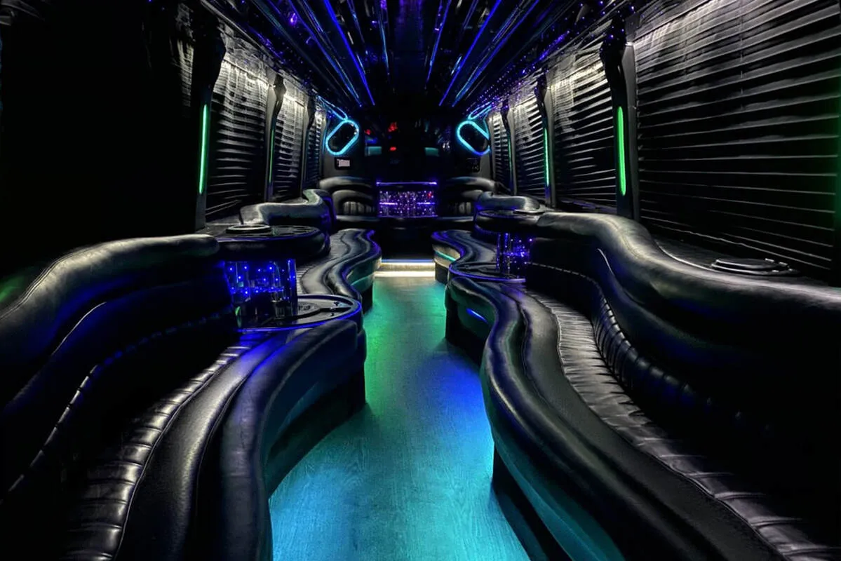 Entertainment Coach interior with perimeter lounge seating, window shades and LED accent lighting for party bus rental Entertainment Coach interior with perimeter lounge seating, window shades and LED accent lighting for party bus rental
