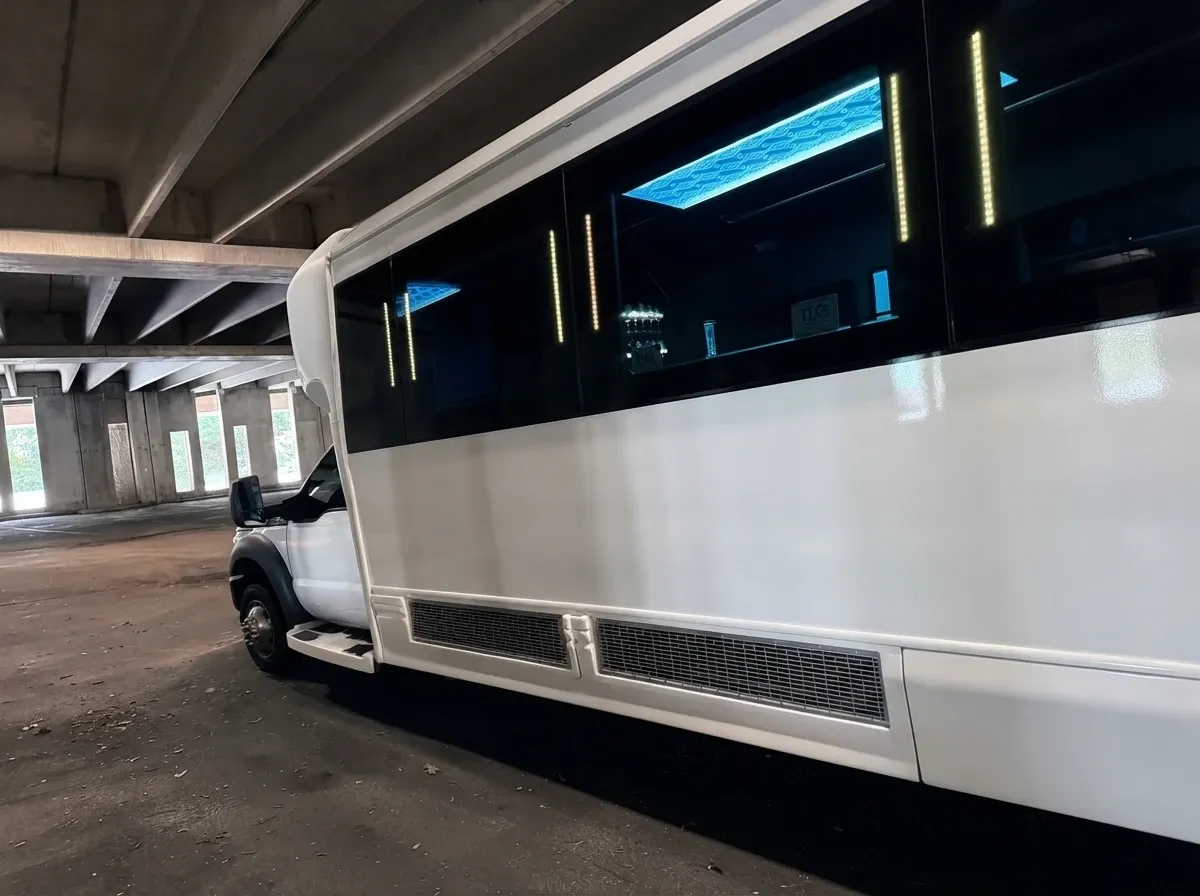 White Ford F-550 Party Bus exterior with tinted windows, panoramic windows and high-roof cabin, photo 7 for limo rental in Hampstead, NH White Ford F-550 Party Bus exterior with tinted windows, panoramic windows and high-roof cabin, photo 7 for limo rental in Hampstead, NH