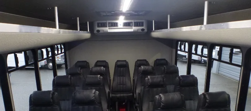 32 Passenger Ford F600 Executive VIP Shuttle Bus interior with overhead parcel racks for charter bus rental in Kenmore, WA