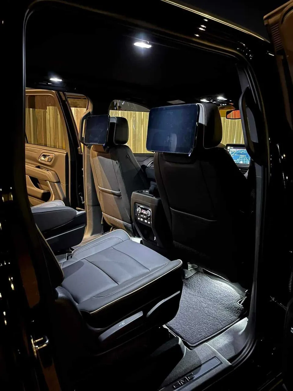 GMC Yukon interior with captain's chairs and rear-seat entertainment screens for airport transfers