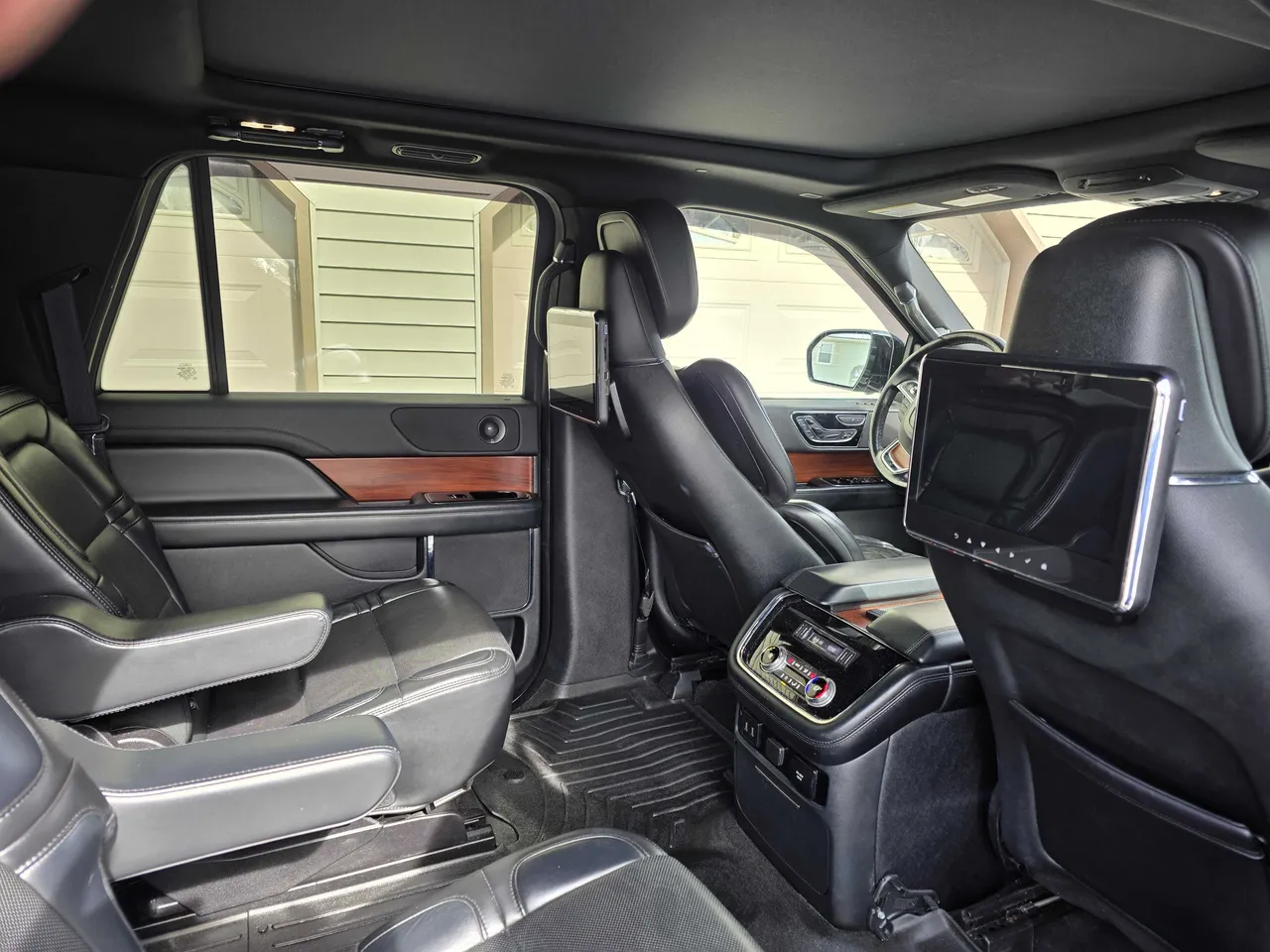 Lincoln Navigator interior with captain's chairs, rear passenger controls and rear-seat entertainment screens for airport transfers