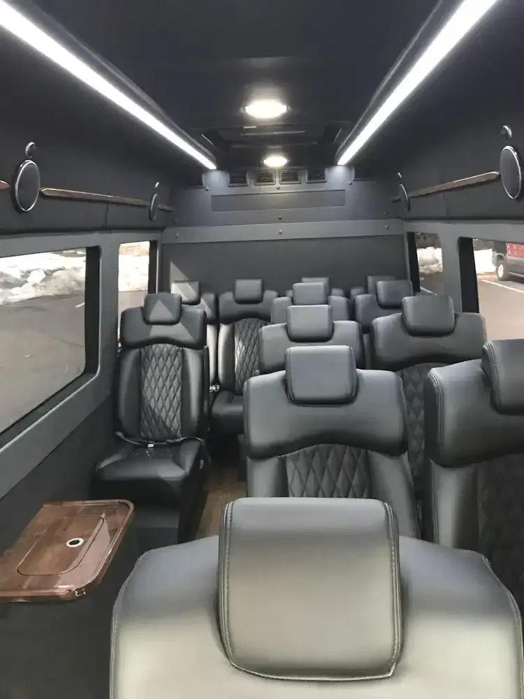 Mercedes Executive Sprinter interior with captain's chairs, passenger tables and LED ceiling lighting for mercedes sprinter rental in Michigan
