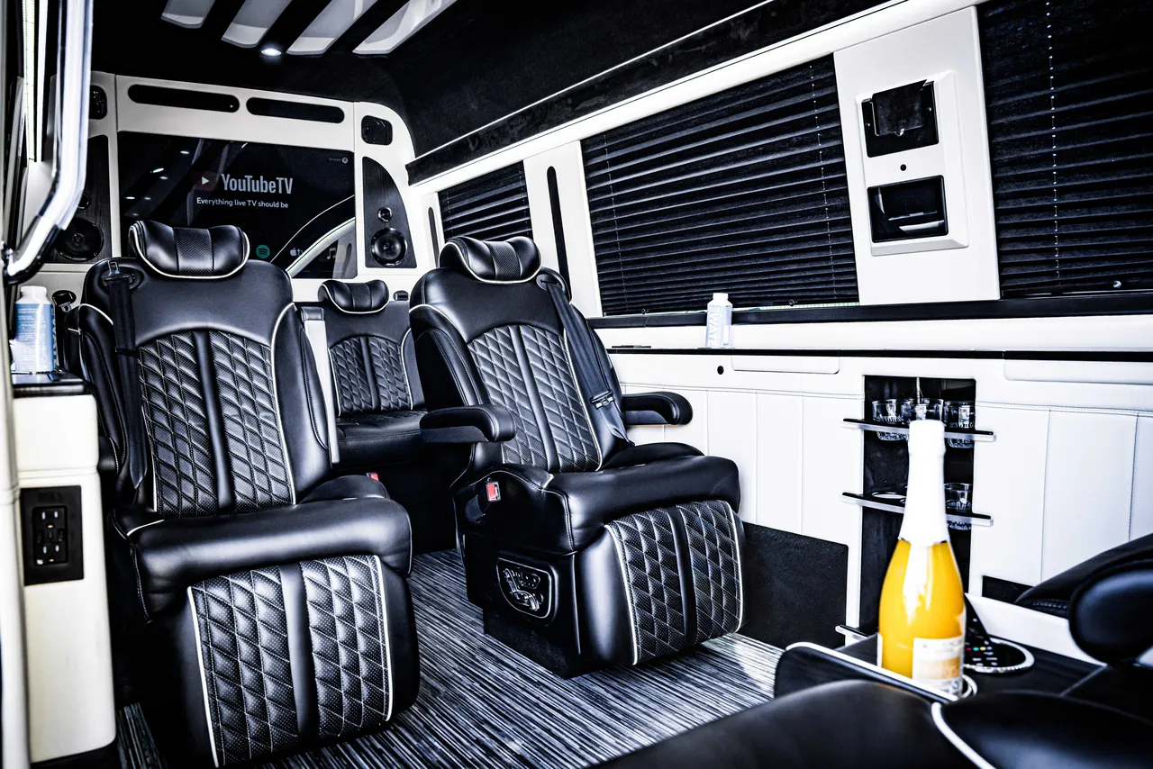 Mercedes Jet Sprinter interior with captain's chairs, window shades and TV screens for winery tour transport