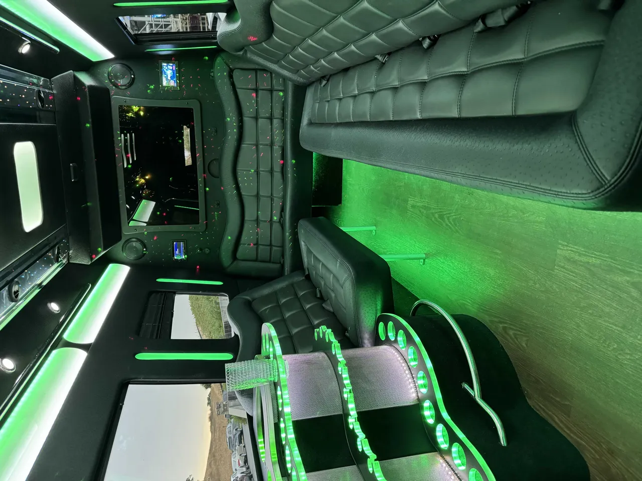 Mercedes Party Bus interior with perimeter lounge seating, LED accent lighting and wood-look flooring for party bus rental in Burlingame, CA