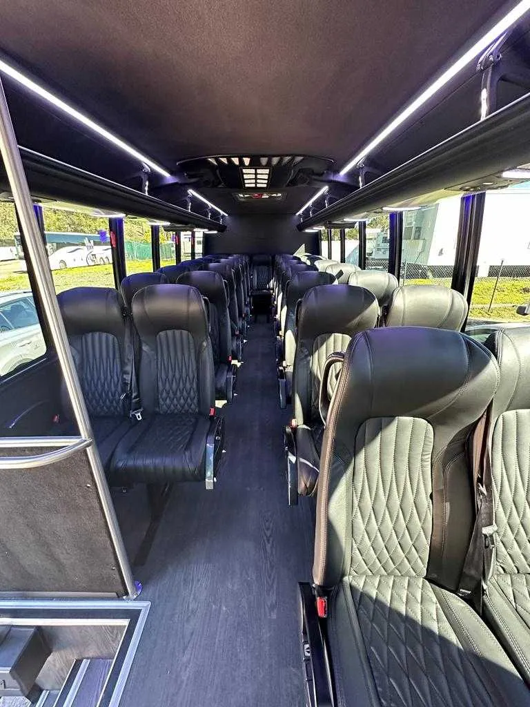 27 Passenger Mini Coach interior with LED ceiling lighting, passenger seat belts and overhead parcel racks for minibus rental 27 Passenger Mini Coach interior with LED ceiling lighting, passenger seat belts and overhead parcel racks for minibus rental