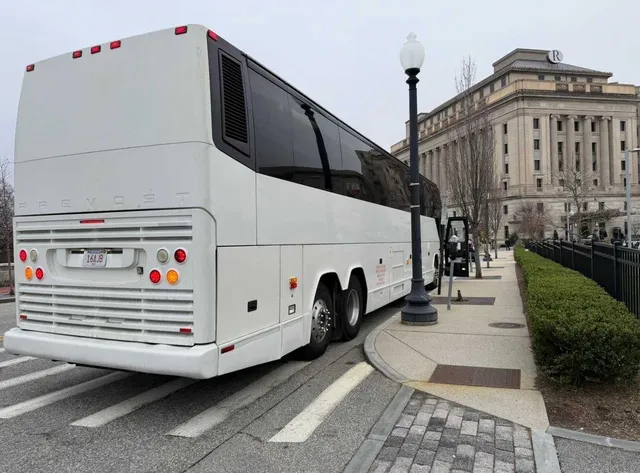 White 55 Passenger Motorcoach exterior with tinted windows for charter bus rental in Clinton, CT