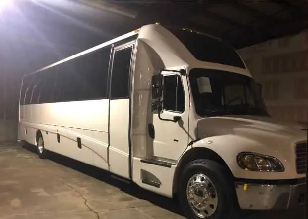 White 44 Passenger Motorcoach exterior with tinted windows for charter bus rental in Piseco, NY