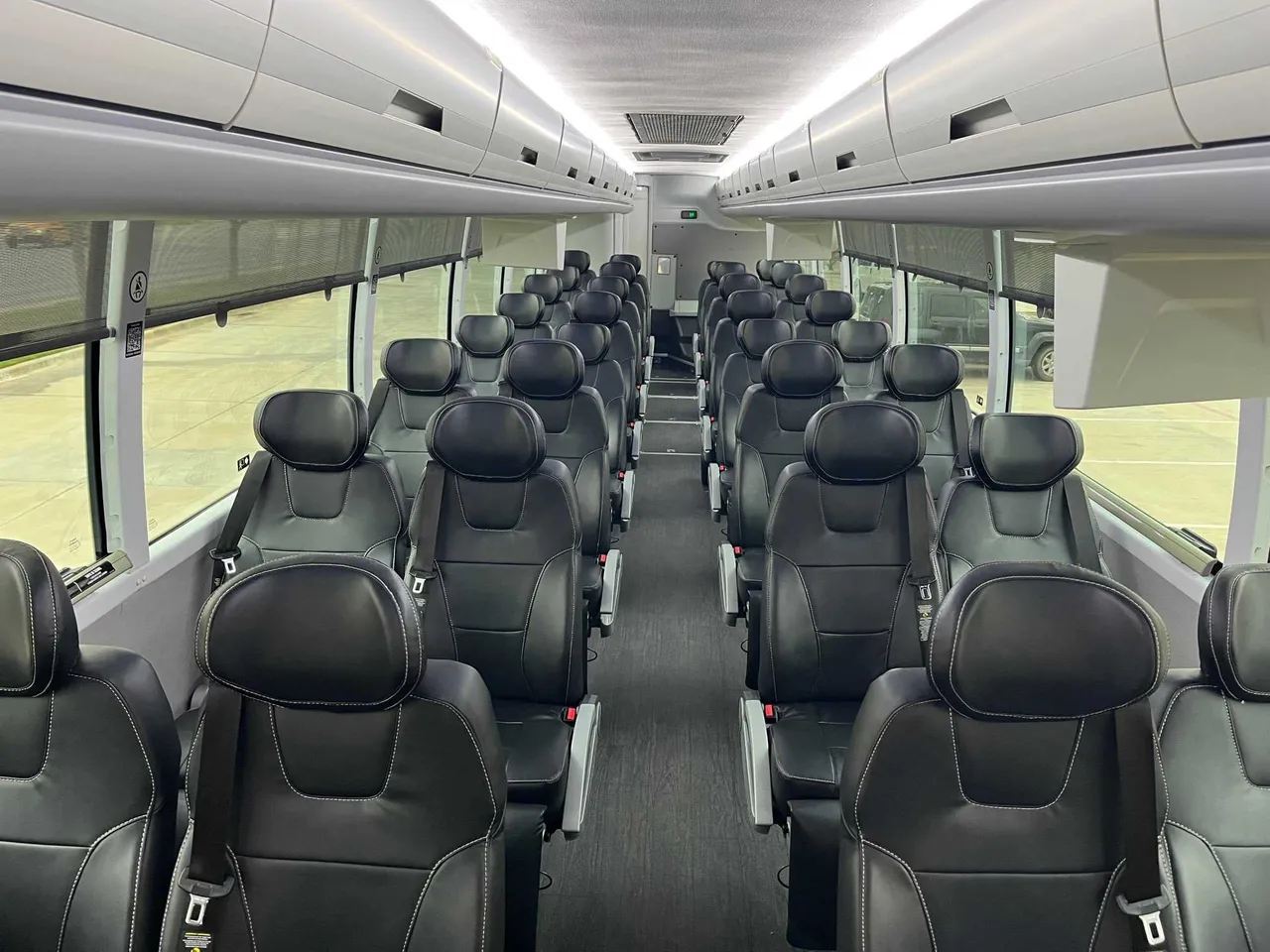 Executive Recliner Motorcoach interior with window shades, LED ceiling lighting and overhead parcel racks for charter bus rental in Corpus Christi, TX Executive Recliner Motorcoach interior with window shades, LED ceiling lighting and overhead parcel racks for charter bus rental in Corpus Christi, TX