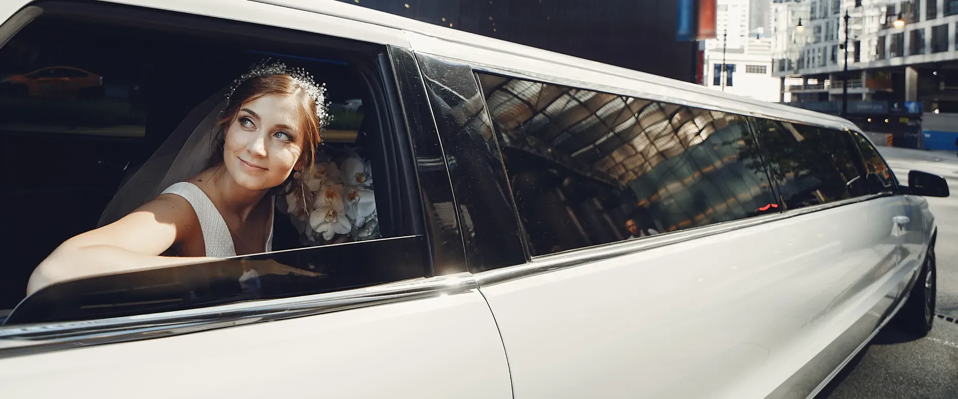 A bride stepping into a white stretch limousine