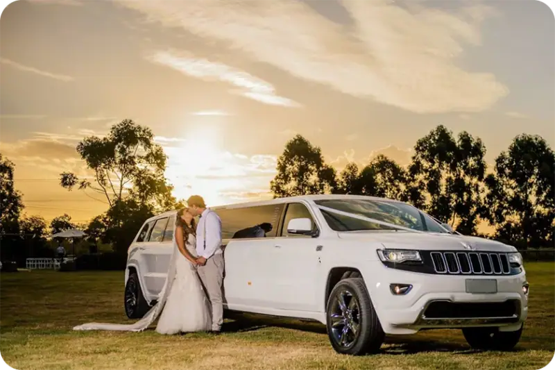 Newlyweds beside a white stretch limousine